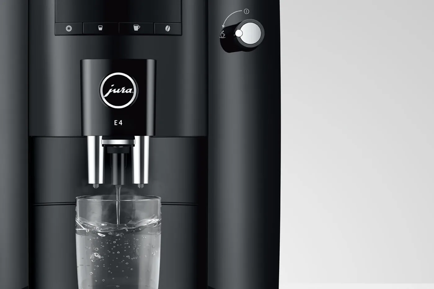 Jura E4 dispensing hot water into a glass under the symbol display